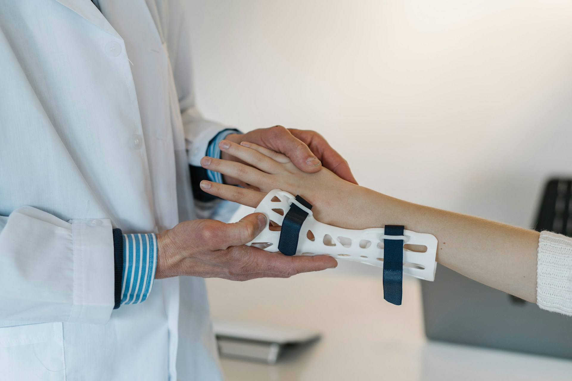 A doctor placing a a brace on a child with a hand injury.